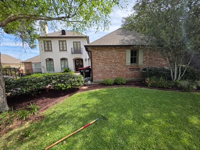 Two-story home with refreshed mulch beds and manicured lawn Louisiana
