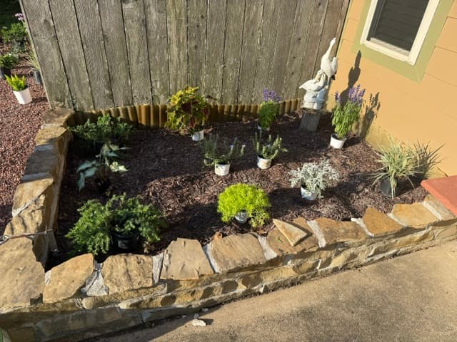 Raised stone flower bed with plants staged for installation Louisiana