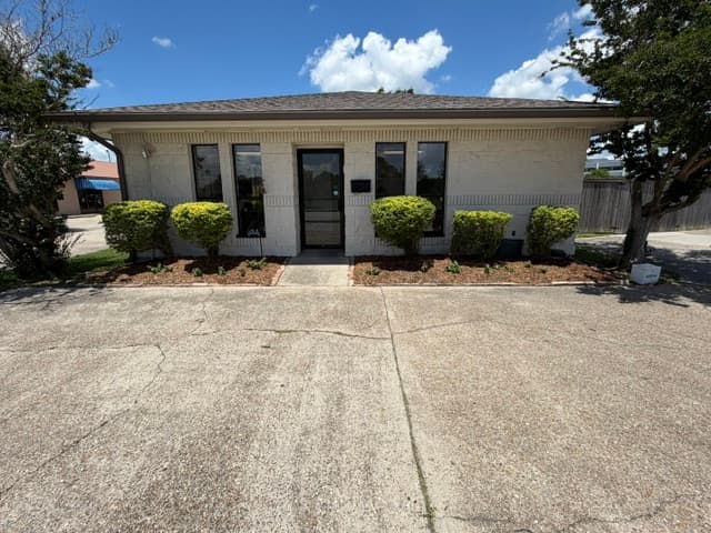 Commercial storefront with trimmed shrubs and fresh flower beds Louisiana