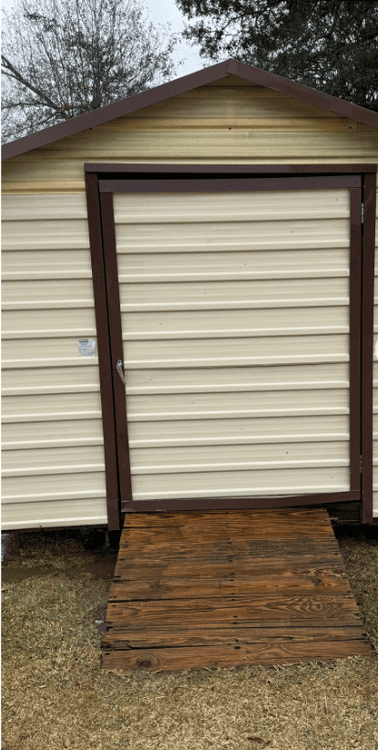Shed front with clean siding and restored wood ramp after pressure washing