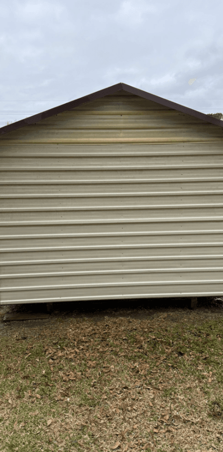 Shed gable end restored to original cream color after pressure washing